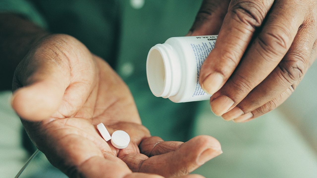 African American man taking medication