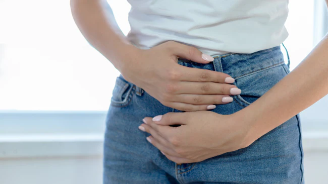 Woman with lower gut pain clutching her gut