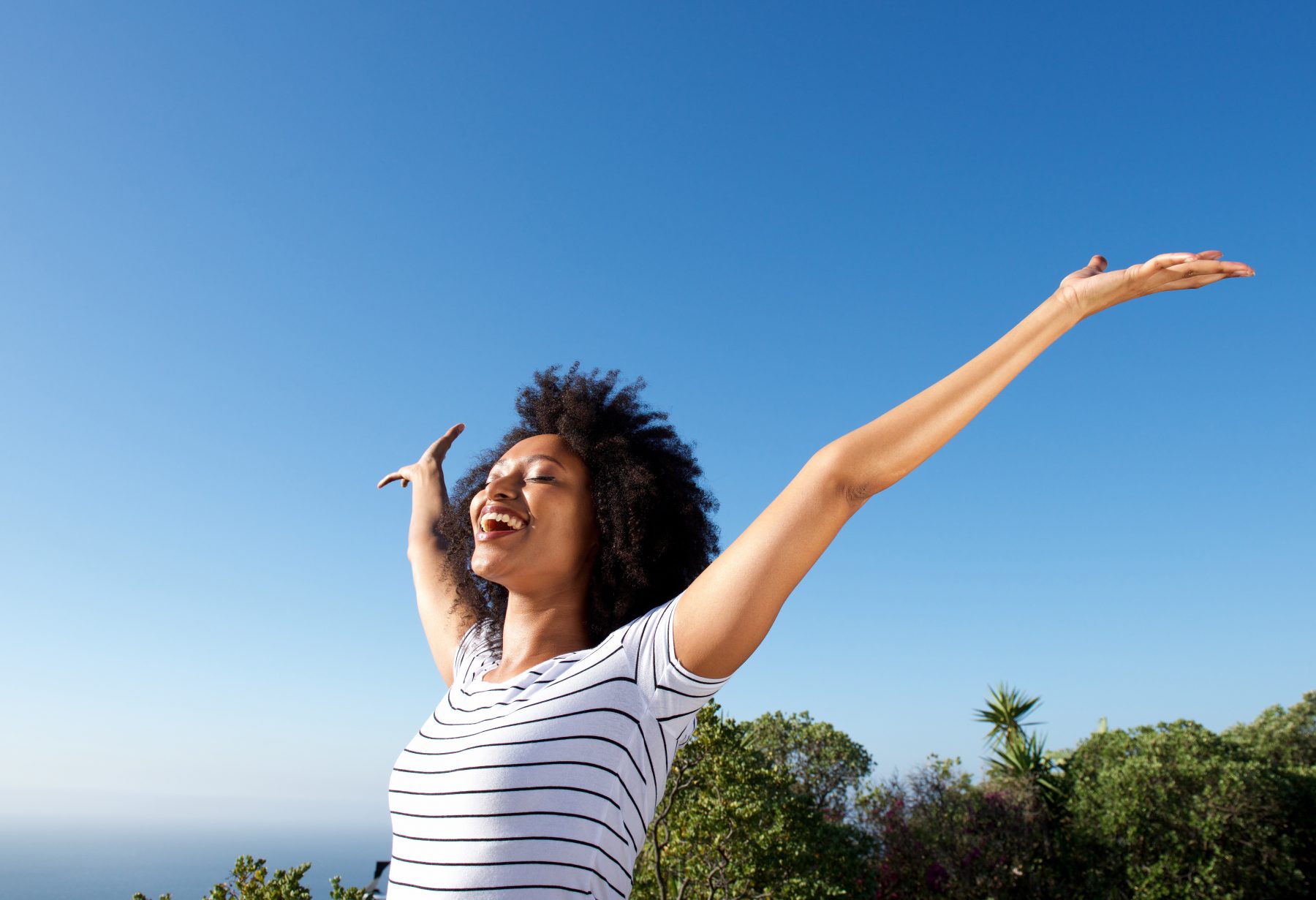 Young African American woman standing outdoors celebrating her health