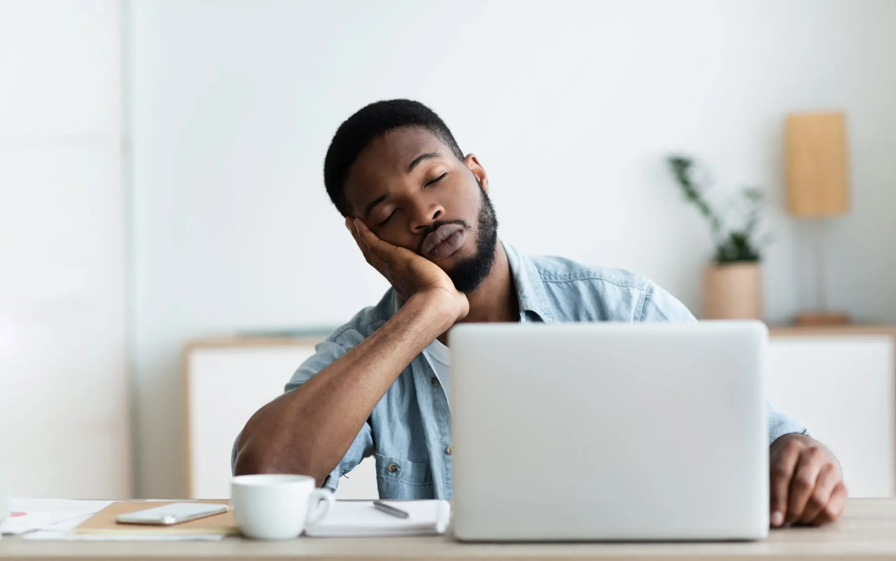 Fatigued man asleep in front of his computer in an office