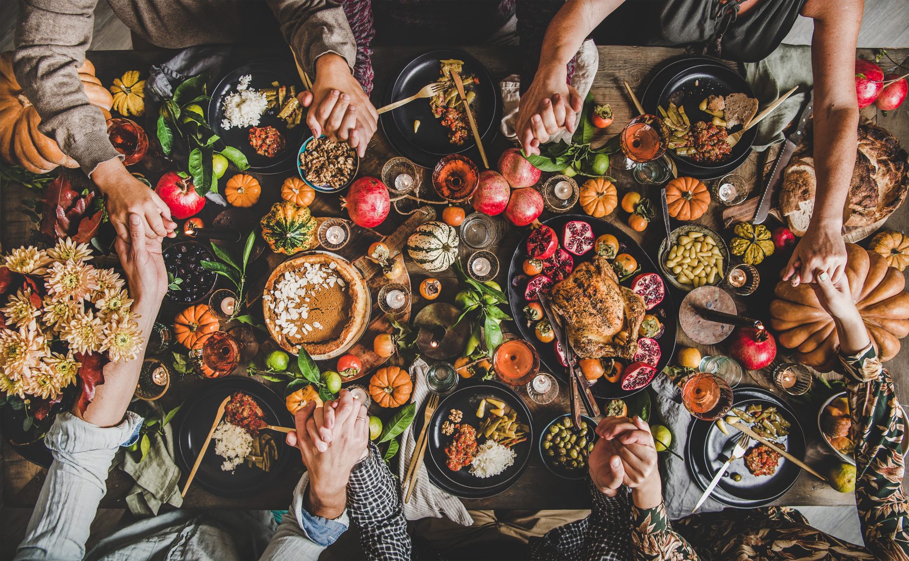 Family and friends praying at the Thanksgiving feast