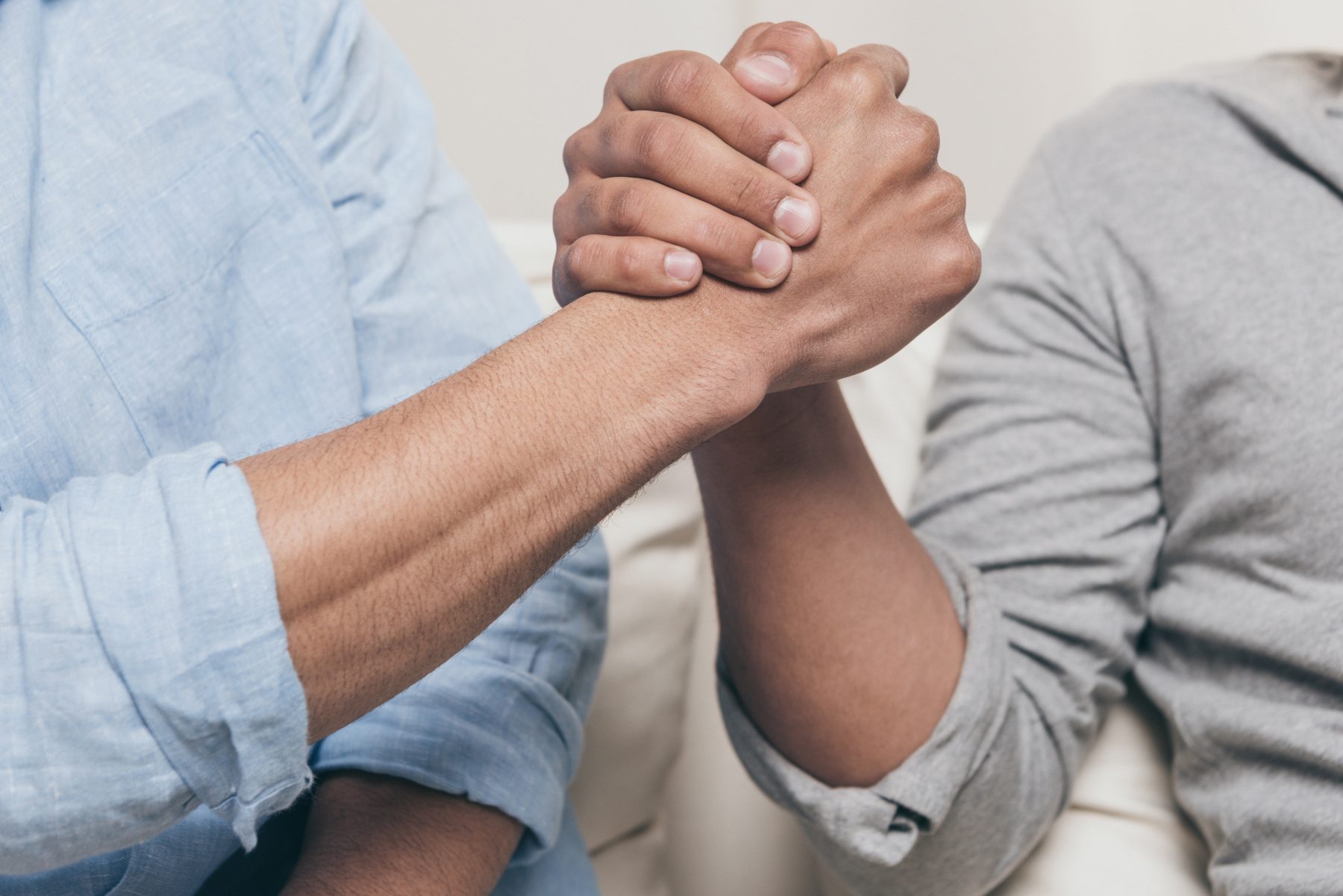 Man and woman with hands clasped together in support