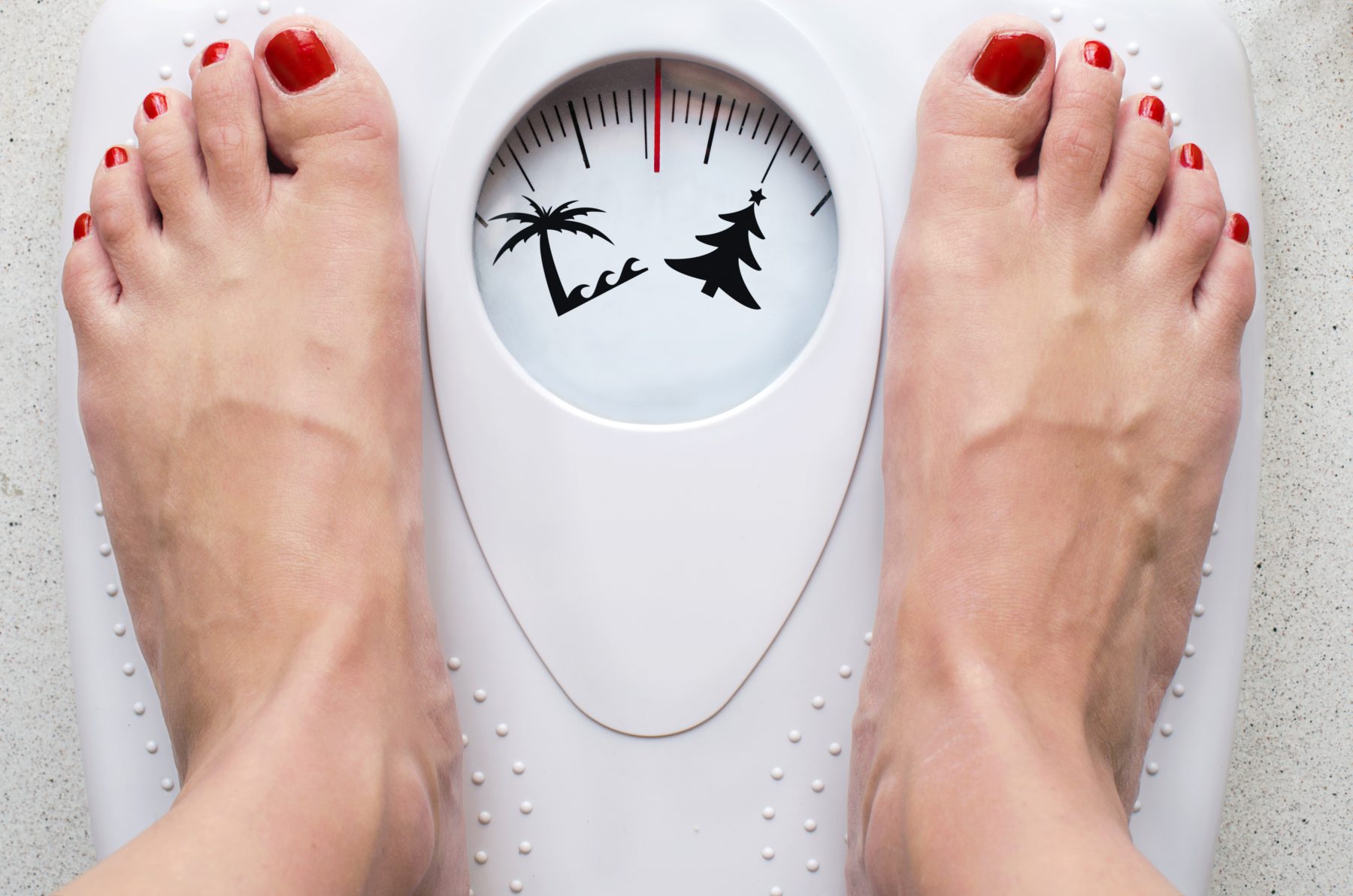 Woman on scale showing weight gain for the holidays