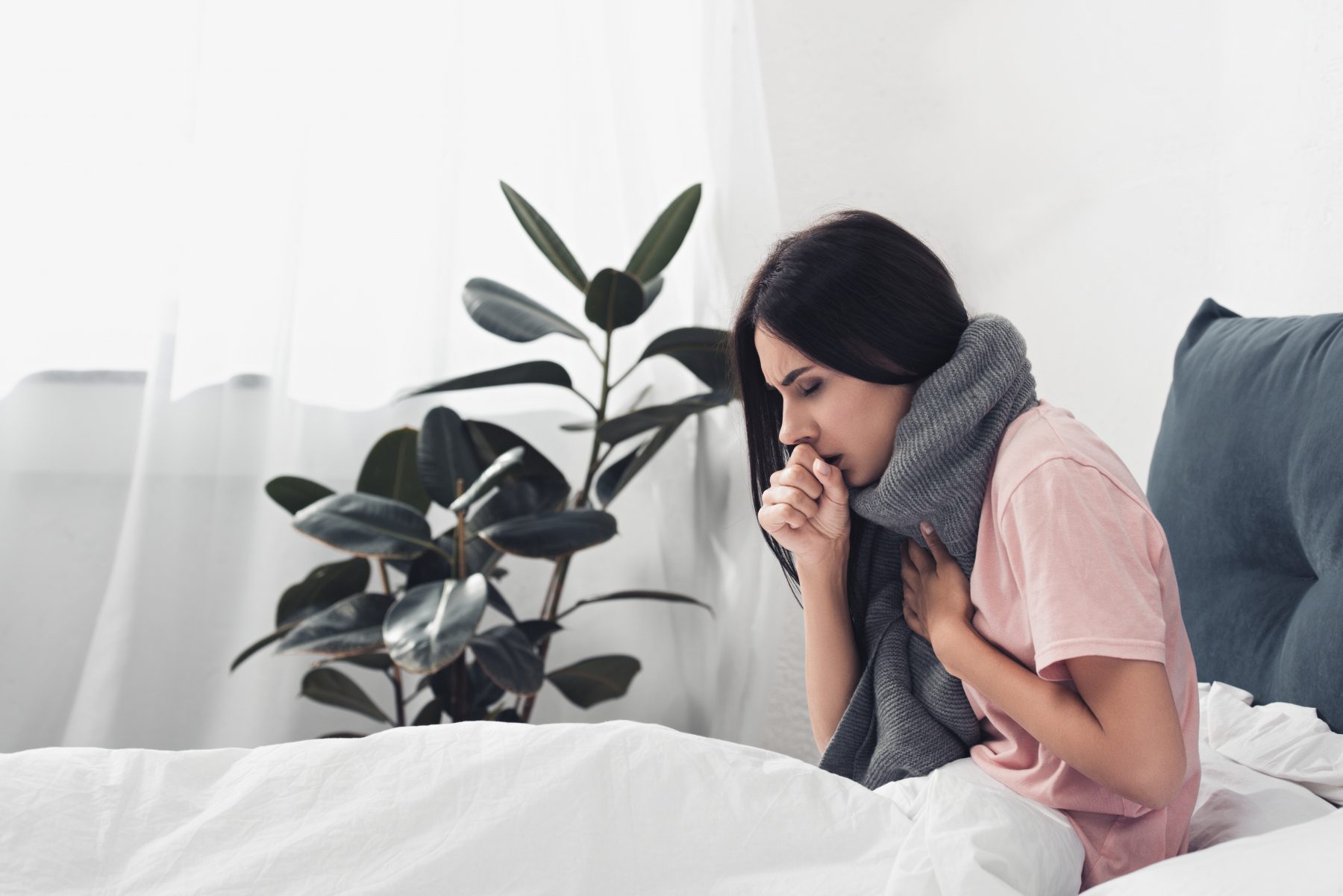 Woman with a cold coughing in bed