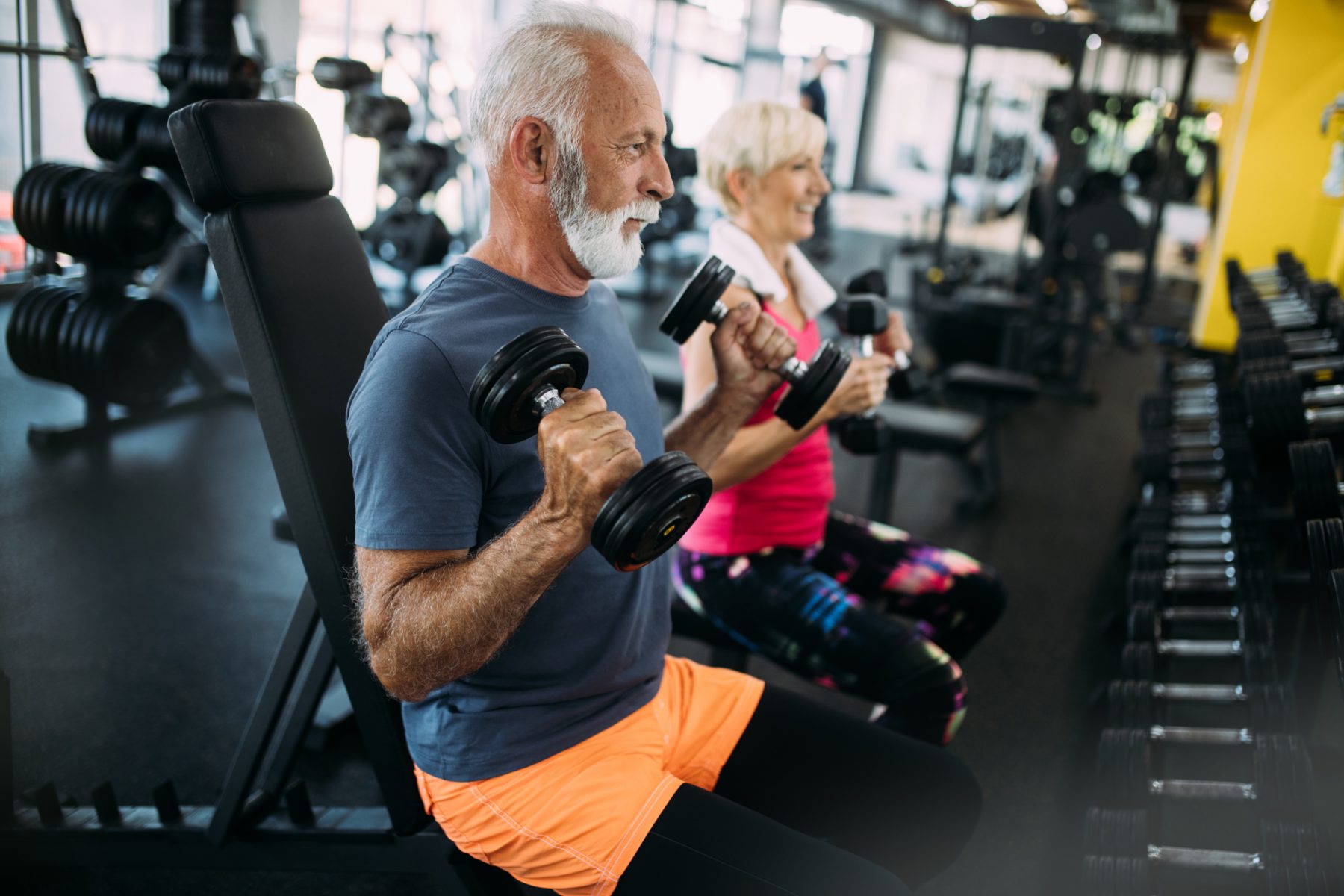 Happy senior people doing exercises in gym to stay fit