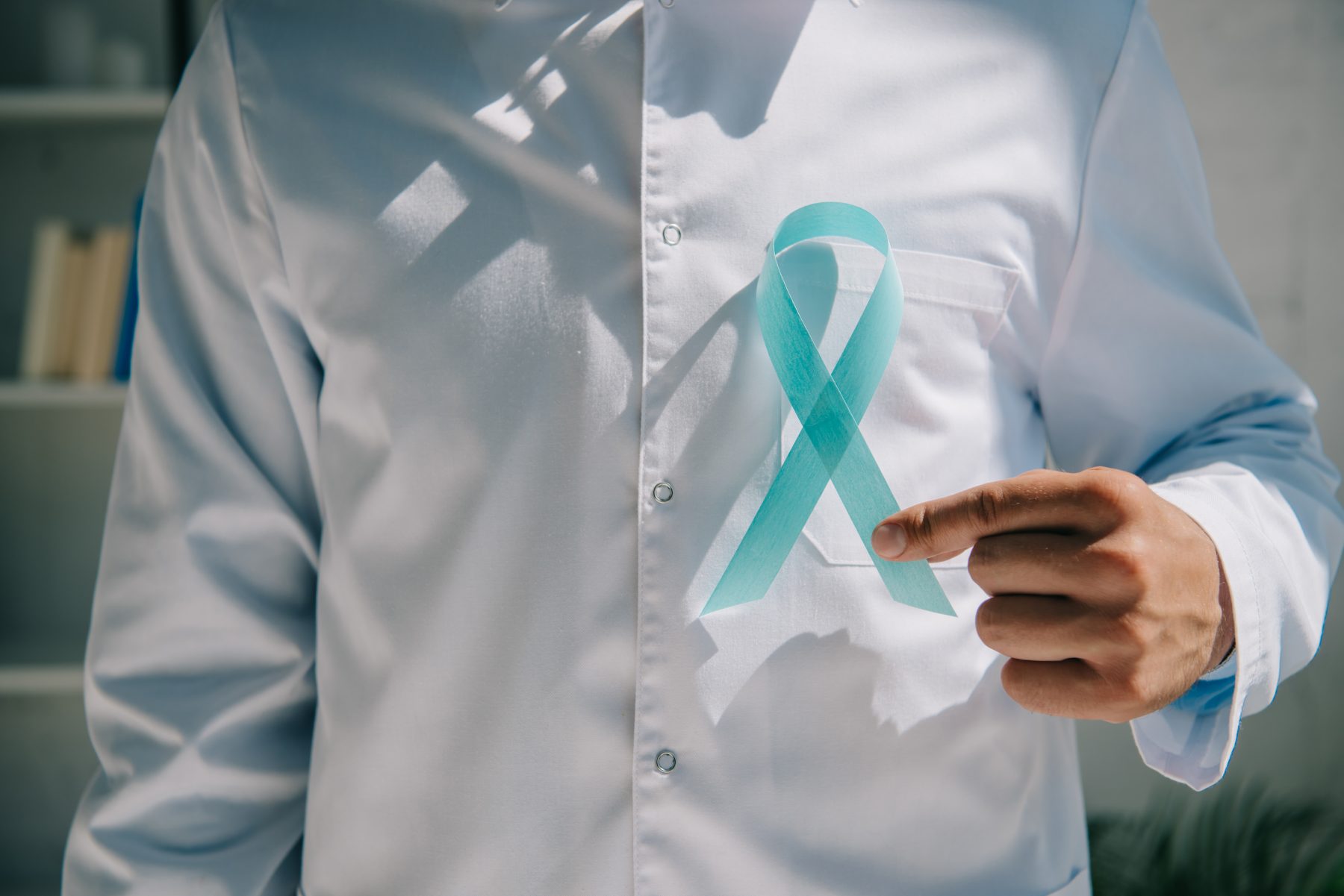 Doctor holding blue ribbon to support prostate health