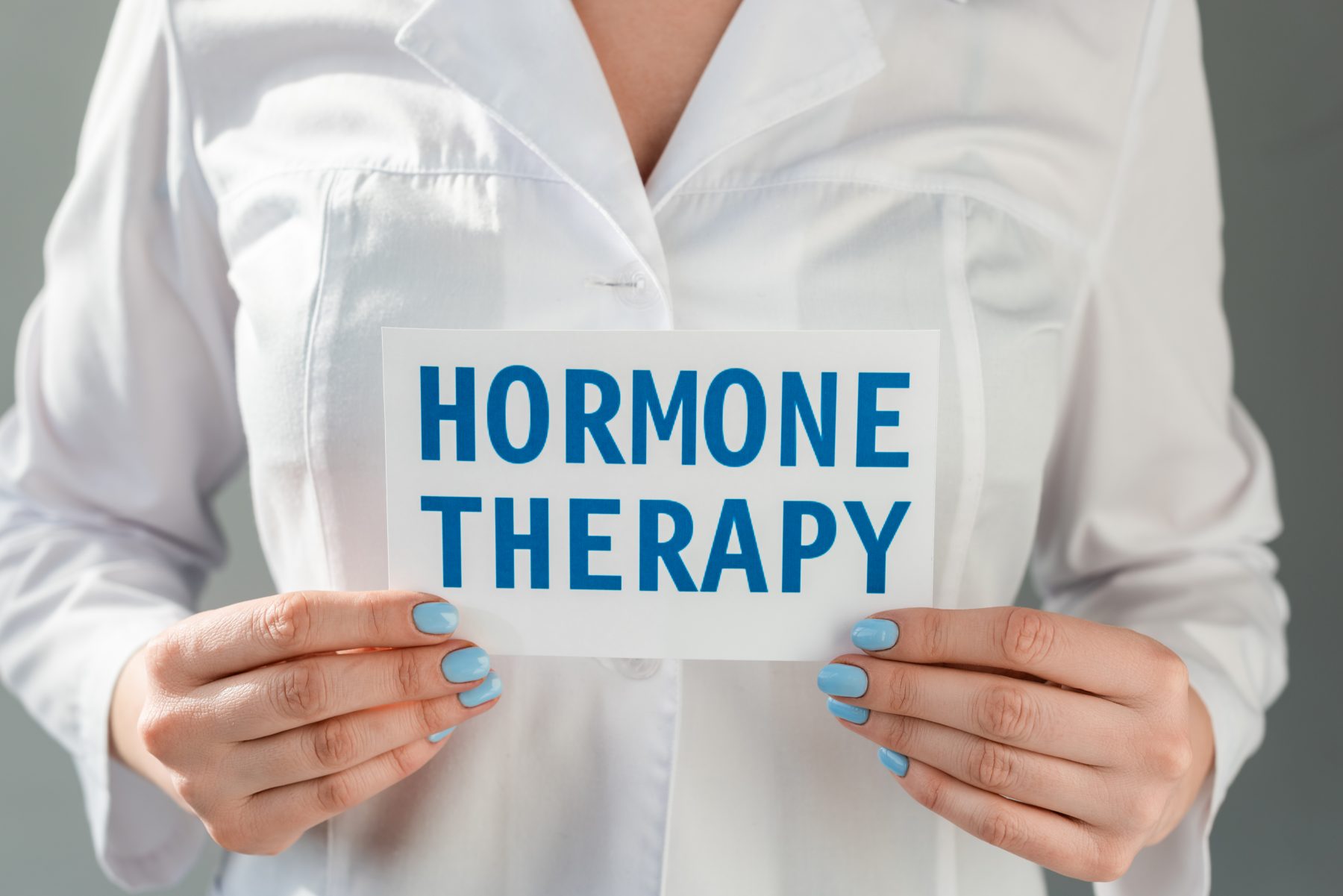 Woman holding sign that reads Hormone Therapy