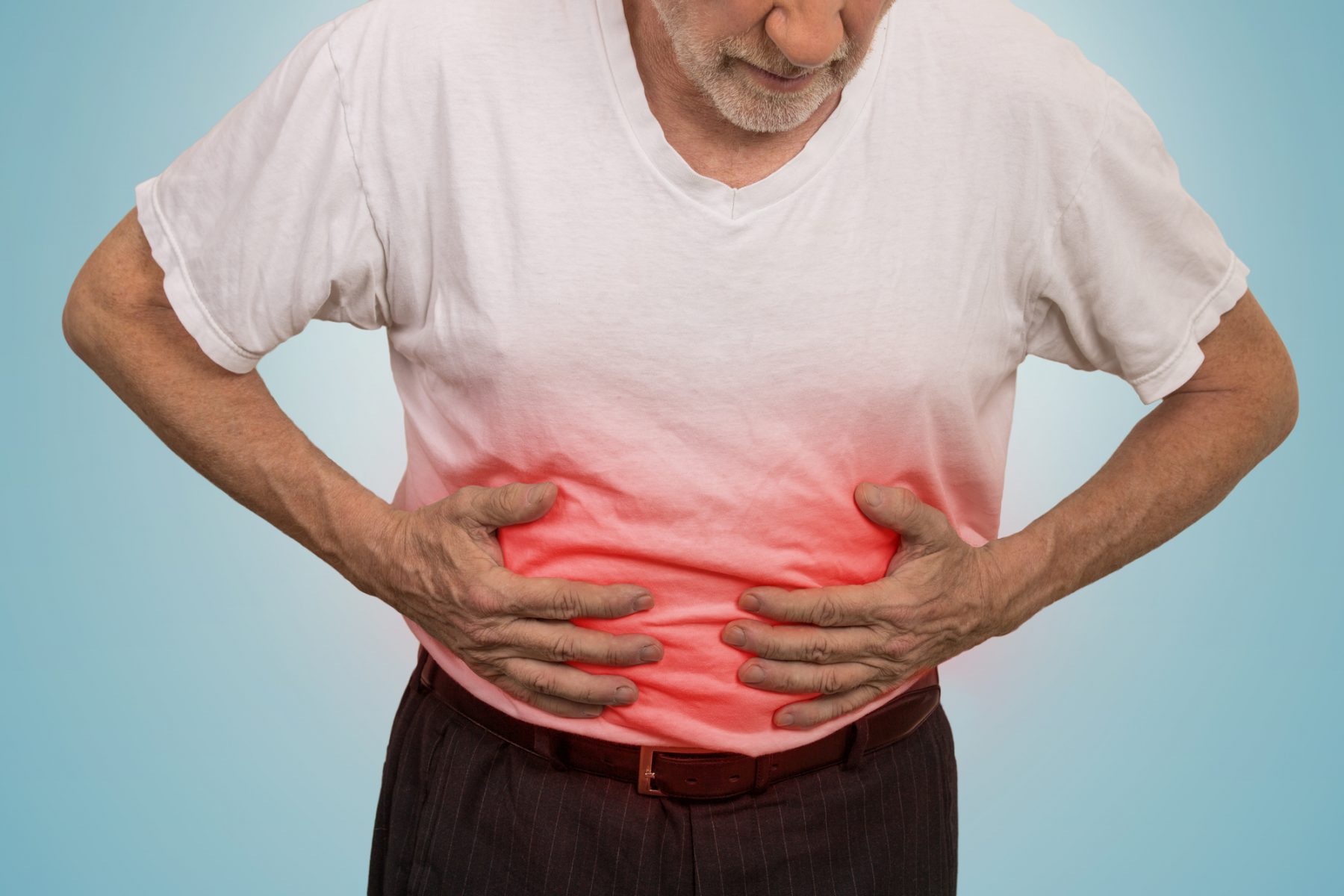 Man suffering from gut inflammation clutching his belly with redness showing