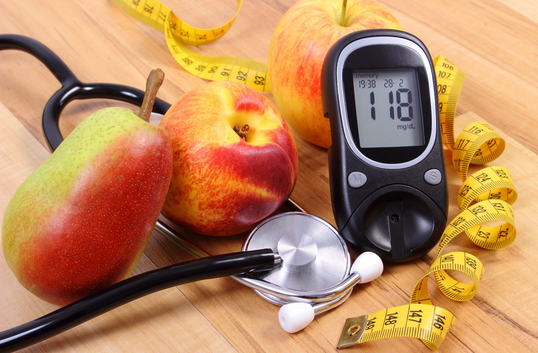 Diet and Diabetes represented by fruit and blood sugar monitor