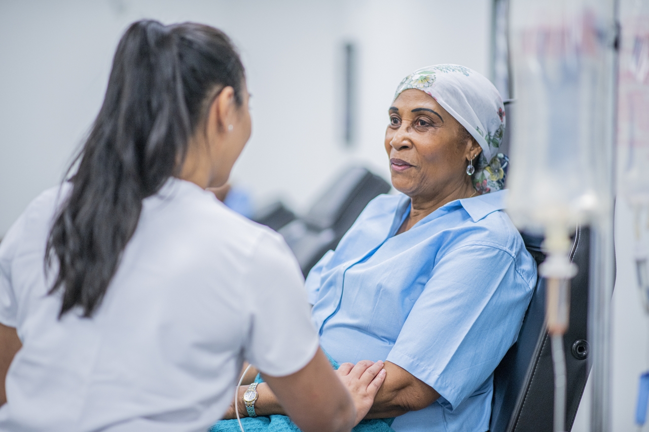 Elderly woman undergoing cancer treatment being treated humanely by nurse