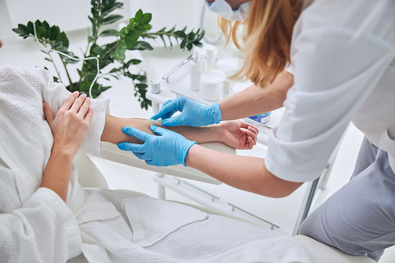 Technician giving ozone IV therapy to patient