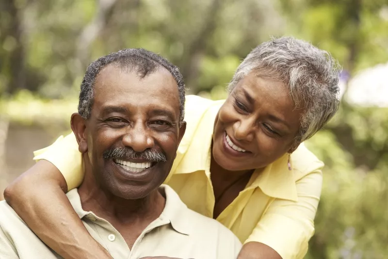 Elderly African American couple hugging and smiling