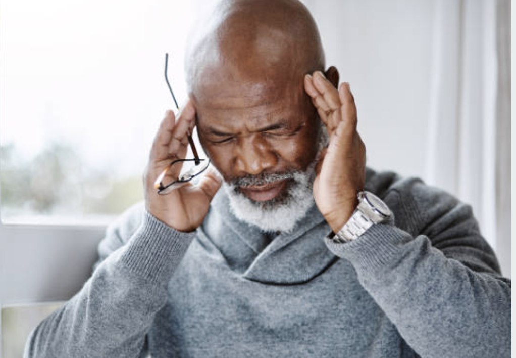 Elderly Man with headache clutching his temples