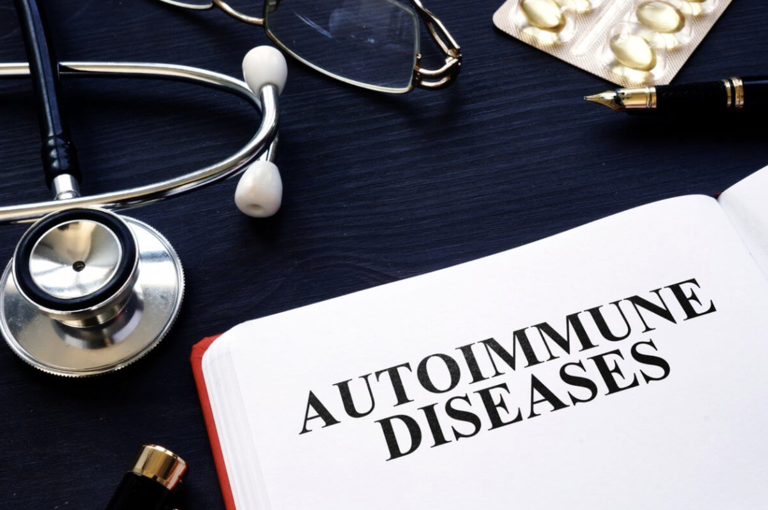 Book with the title Autoimmune Diseases surrounded by medical equipment and fish oils