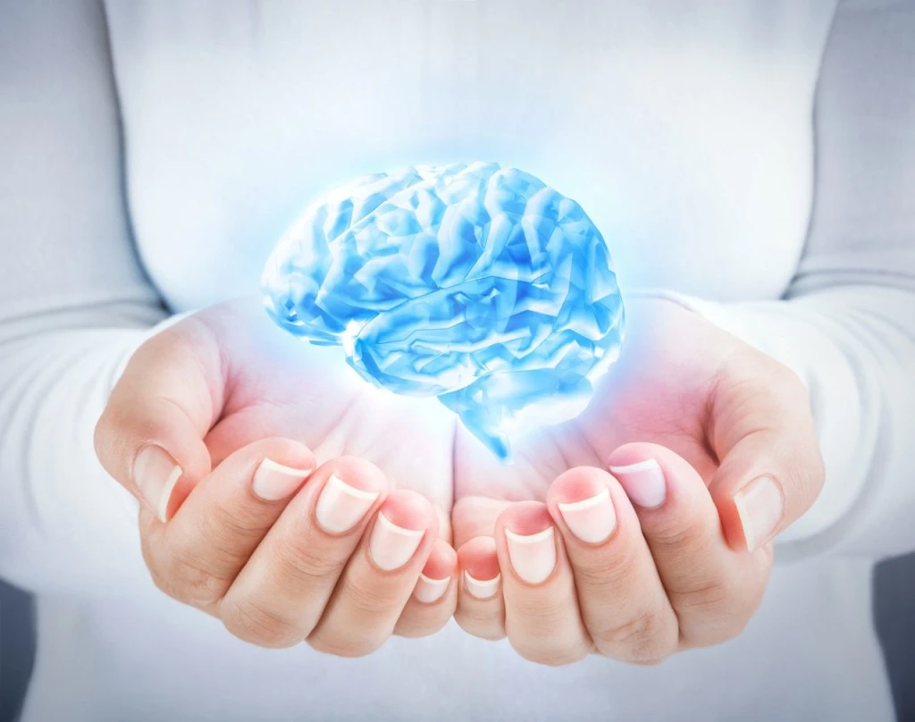 Person dressed in white levitating an image of a brain in their hands