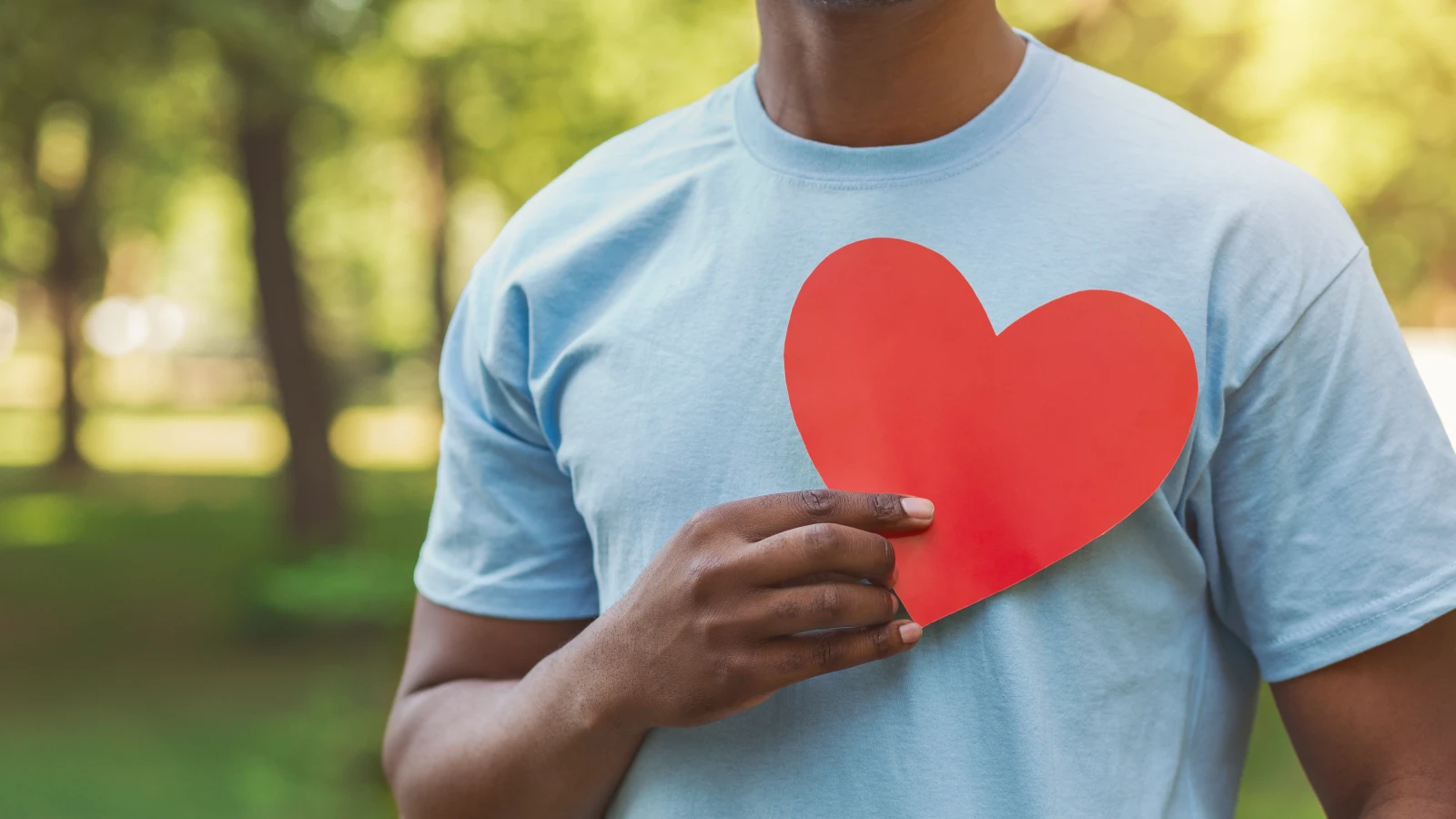 Man holding paper cut out heart over his chest