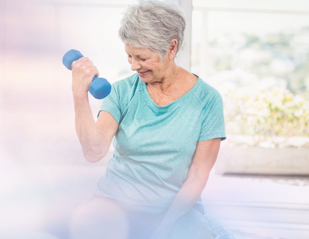 Elderly woman exercising with weights and smiling