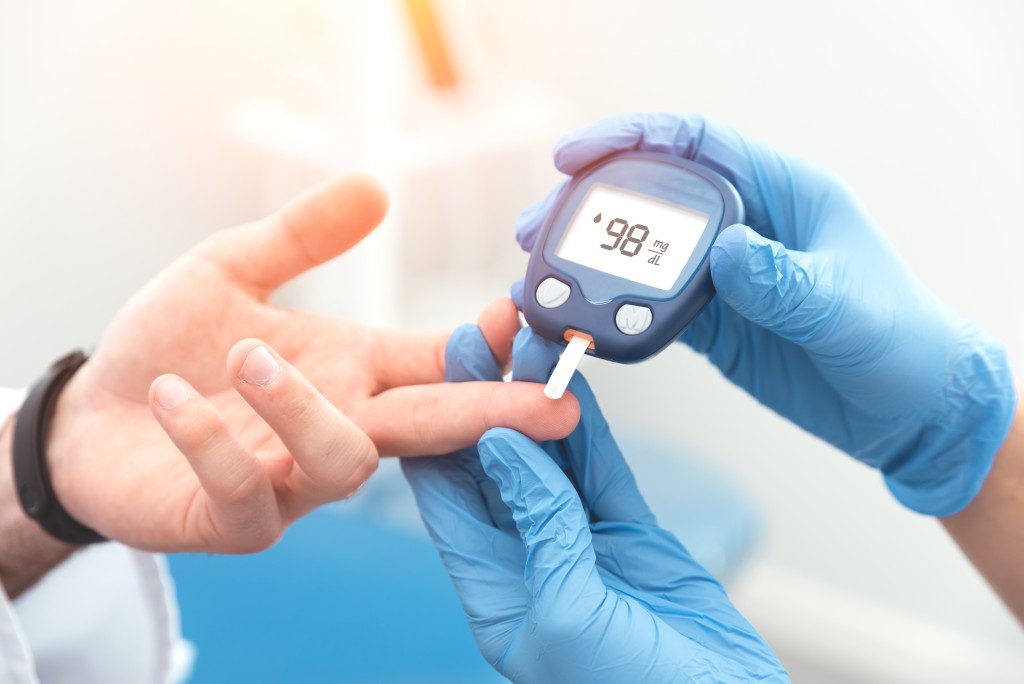 Doctor testing a patient's blood sugar