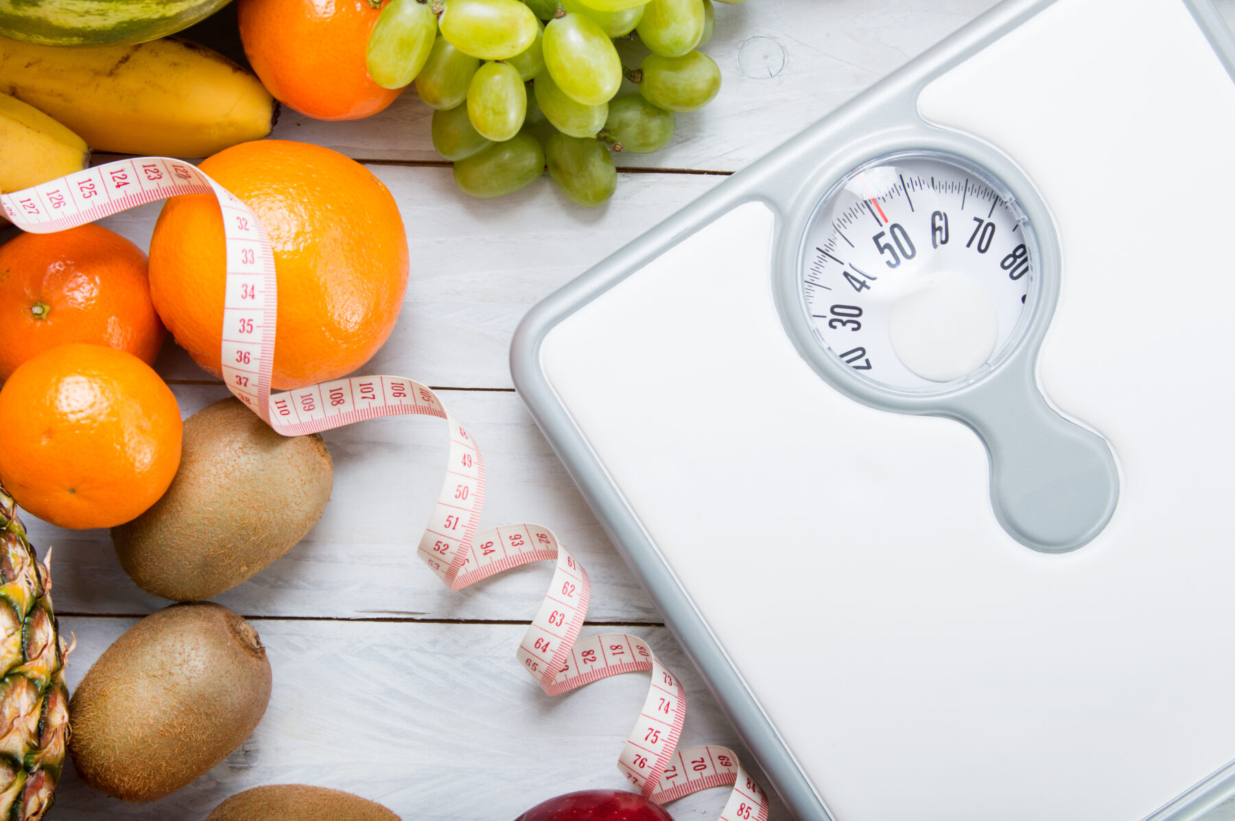 scale and healthy foods representing lifestyle changes for healthy weight loss