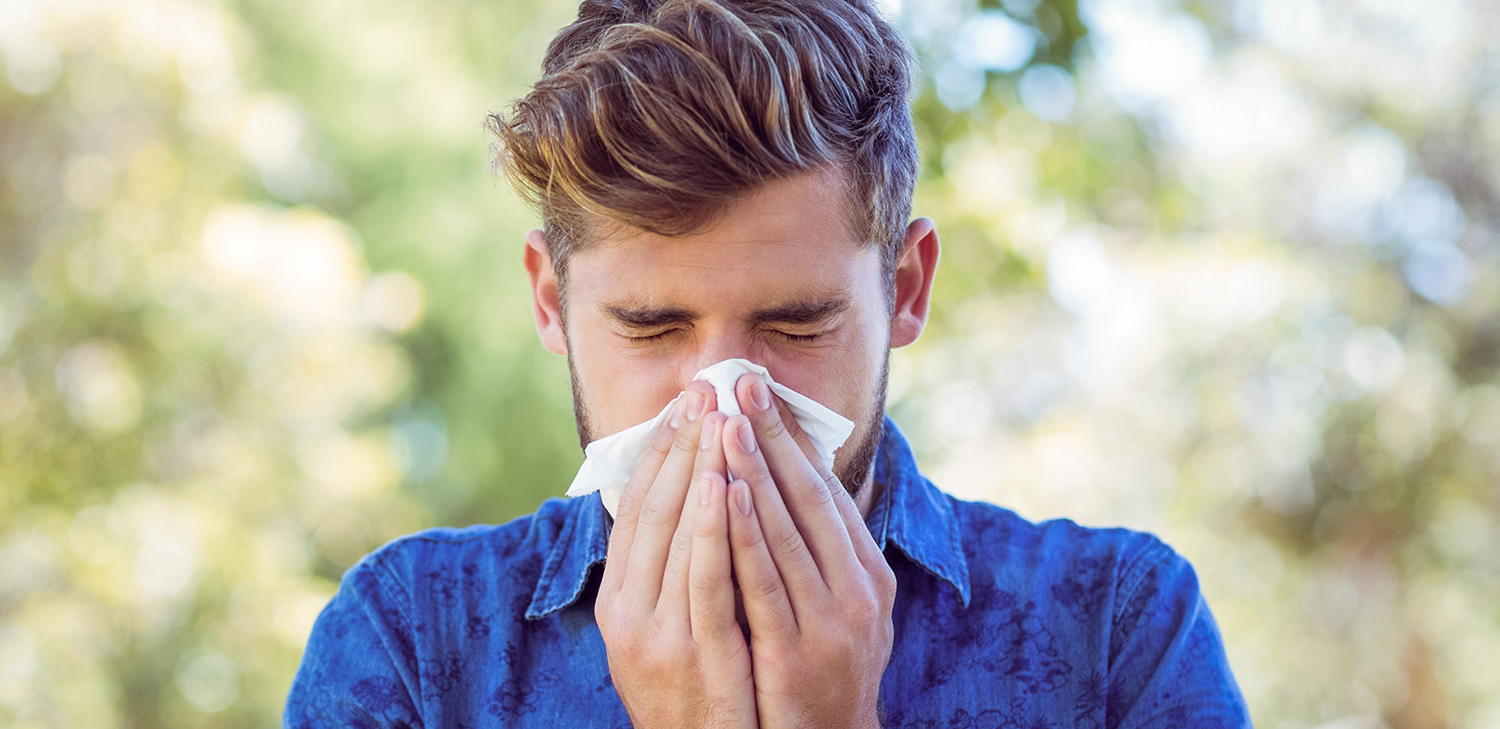 Man sneezing from allergies
