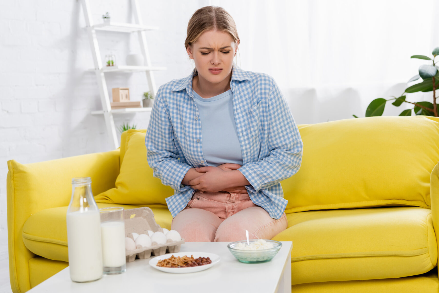 Woman clutching belly from food allergies.